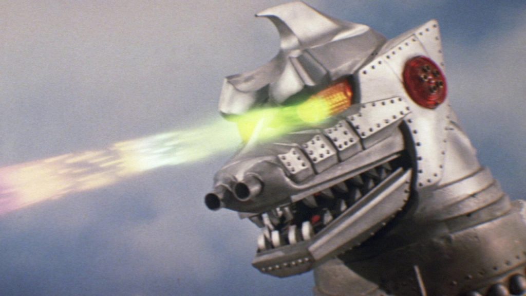 This is a film still from GODZILLA VS MECHAGODZILLA (ゴジラ対メカゴジラ, Gojira tai Mekagojira) dir Jun Fukuda (1974) showing a giant robot dinosaur firing lasers from its eyes.