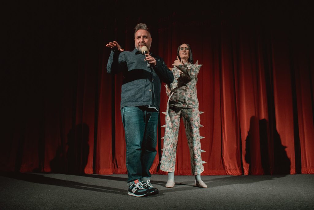 Token Homo tries to be nice to Loose Willis on his birthday, but gets assaulted by an Xmas tree at our 50th Anniversary celebration of FEMALE TROUBLE at Rio Cinema (13 July 2024).