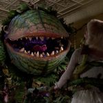 This is a film still from LITTLE SHOP OF HORRORS shoing a giant monstrous plant holding a woman - Audrey - in its tendrils.