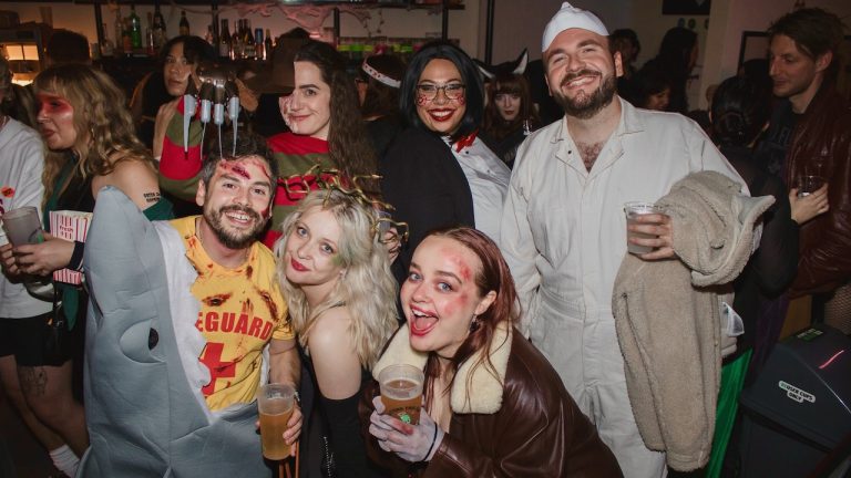 This is a photograph from our Queer Horror Nights pre-drinks for DEMONS, showing various audience members dressed in fancy costume and posing for the camera.