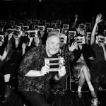 This is a picture of Bar Trash host Token Homo holding up a cardboard 'ghost viewer' and smiling at the camera whilst standing in front of the Bar Trash audience all holding their viewers to thier faces ready to watch William Castle's film, 13 GHOSTS.
